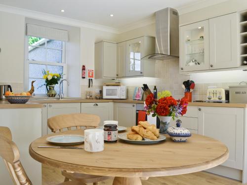 a kitchen with a wooden table with food on it at Curlew Cottage in Meigle