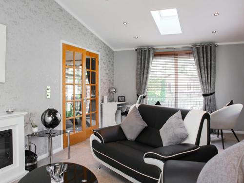 a living room with a couch and a tv at Stag Lodge in Auchterarder