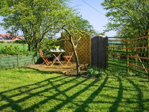 a garden with a table and a fence at The Barn in Cantley