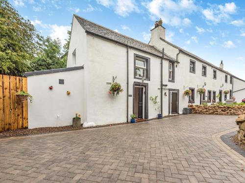 a white house with a brick driveway at The Nook - Uk44735 in Tallentire
