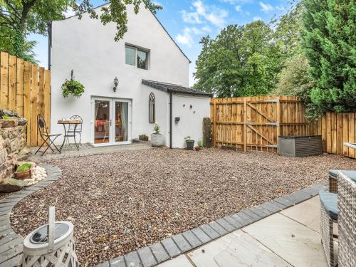 a backyard with a wooden fence and a house at The Nook - Uk44735 in Tallentire