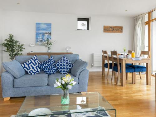 a living room with a blue couch and a table at Apartment 22, Horizon View in Westward Ho