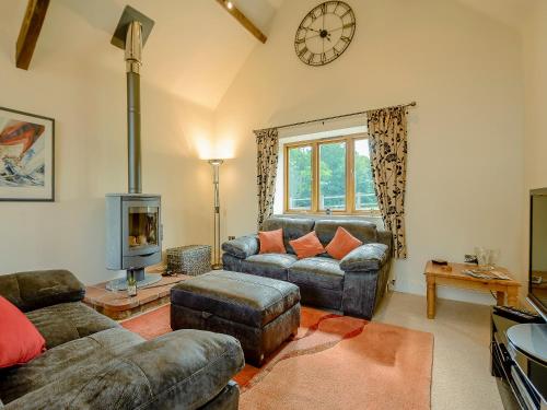 a living room with a couch and a stove at Courtyard Lodge in Edwinstowe