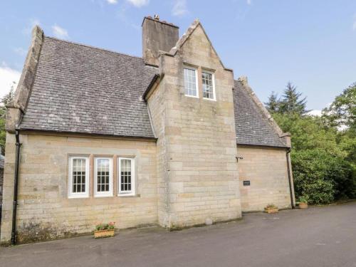 an old brick building with white windows on a street at Gardeners- Uk7233 in Kirkmichael