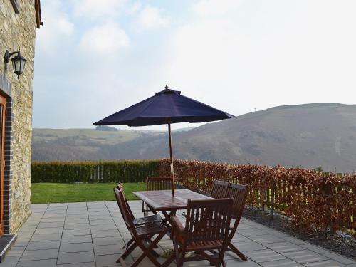 a table and chairs with an umbrella on a patio at Helygen in Talybont