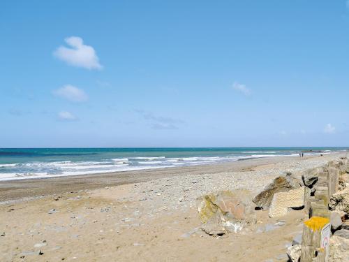 a beach with a fence and the ocean at Helygen in Talybont
