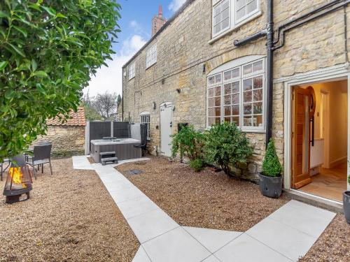 a garden outside a brick building with a patio at The Retreat in Sudbrooke