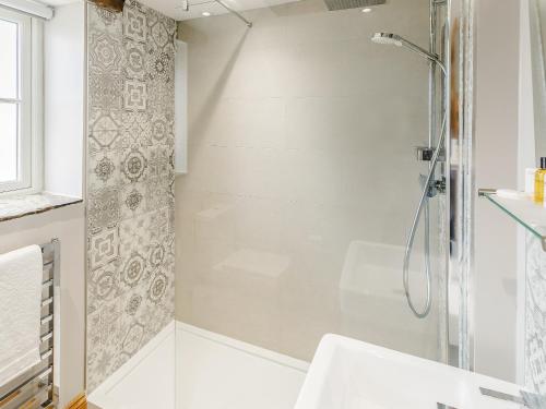 a bathroom with a shower and a sink at Alton Hall Cottage in Ashover