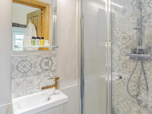 a bathroom with a shower and a sink at Alton Hall Cottage in Ashover