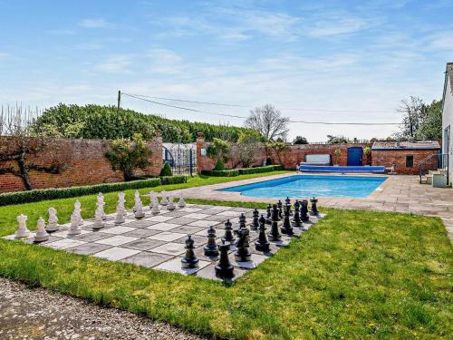 a chess board on a lawn next to a pool at Pengethley Manor - Uk39045 in Peterstow