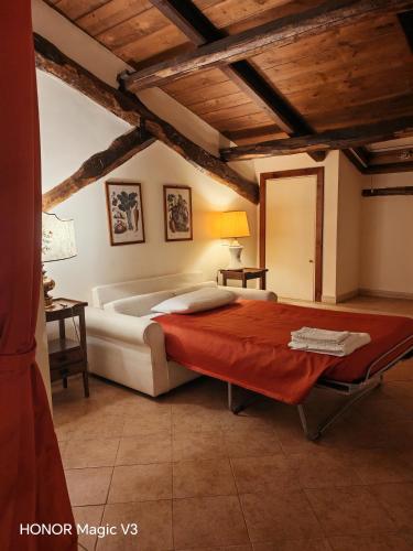 a bedroom with a large bed with a red blanket at Casale DI Tormaggiore Villa And Country Suites in Pomezia