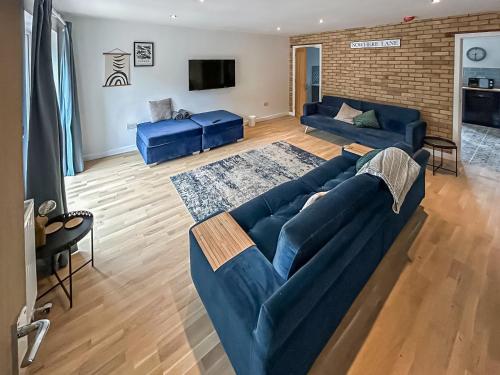 a living room with a blue couch and a tv at No 1 Fox Burrow-Uk44306 in Lenwade