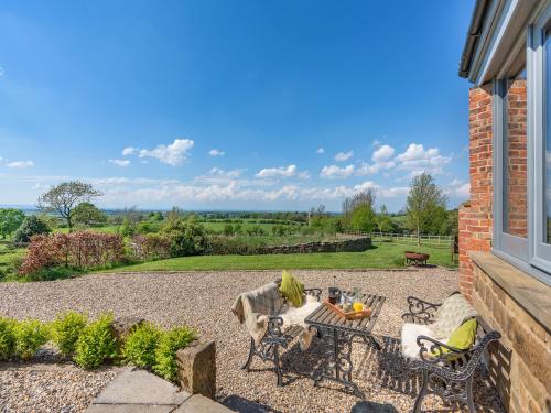 a patio with a table and chairs and a view at The Gin Gang in Whorlton