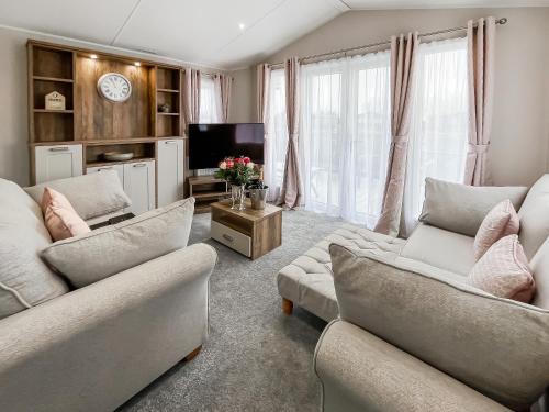 a living room with two couches and a tv at Reed Roost - Uk37726 in Skegness
