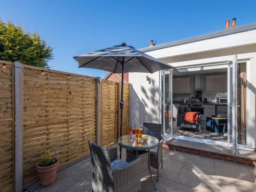 a patio with a table and an umbrella at Peacock Lodge in Thurlton