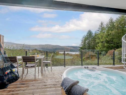 a jacuzzi tub on a deck with a view at Jack Strawbale House - Uk7521 in Strontian