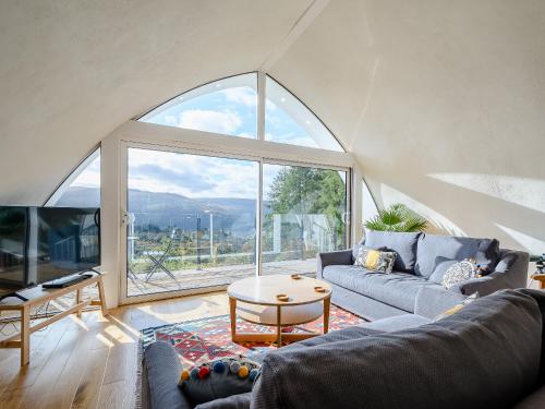a living room with a couch and a large window at Jack Strawbale House - Uk7521 in Strontian