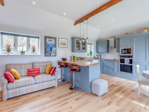 a kitchen and living room with blue cabinets and a couch at The Lodge At Edenbridge in Shepton Mallet