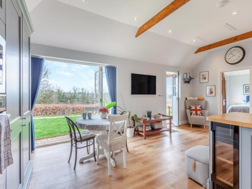a kitchen and living room with a table and chairs at The Lodge At Edenbridge in Shepton Mallet