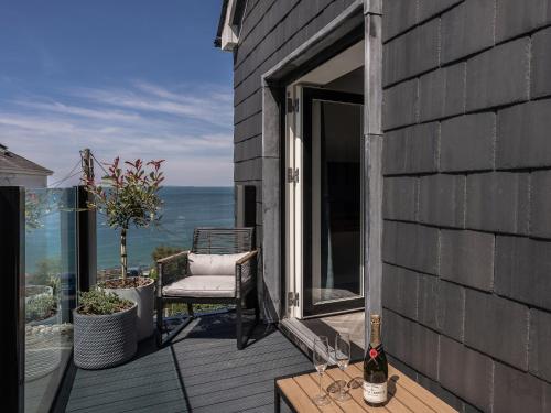 a balcony with a chair and a view of the ocean at Seaglass in Mortehoe