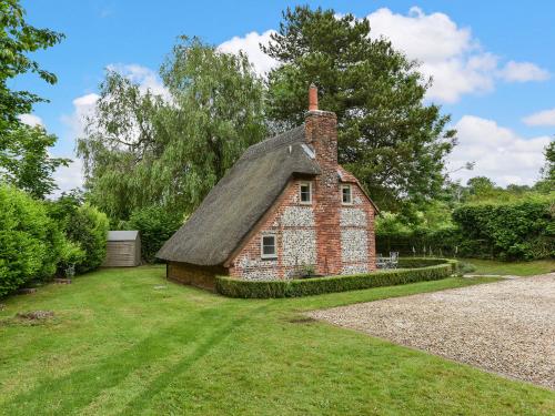 an old brick house with a thatched roof at Peppercorn Cottage in Cheriton