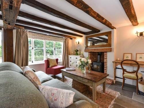a living room with a couch and a fireplace at Peppercorn Cottage in Cheriton