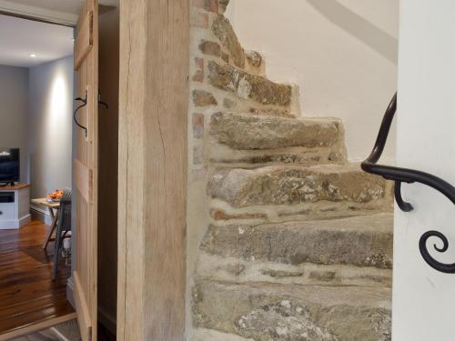 a set of stone stairs in a room with a door at Prospect Cottage in Kettlewell