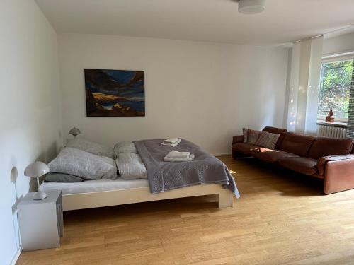 a bedroom with a bed and a couch at Apartment Ammersee in Dießen am Ammersee