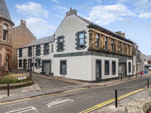 a white building on the corner of a street at The Embassy in Eyemouth