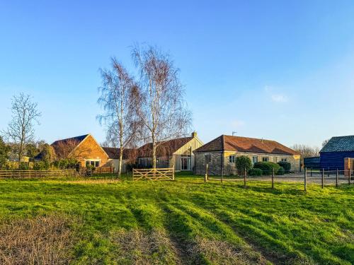 a group of houses in a field with grass at Orchard Barn in Thurlton