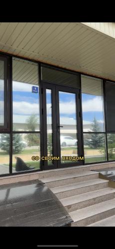 a building with glass windows and steps in front at Радуга in Chon-Sary-Oy