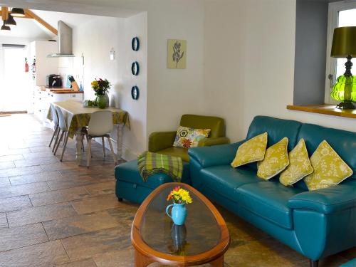 a living room with a blue couch and a table at Bowji in St. Just