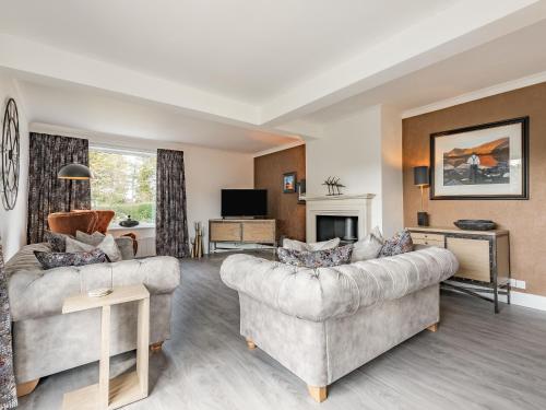 a living room with two couches and a fireplace at Brooksyde,Kippford in Kippford