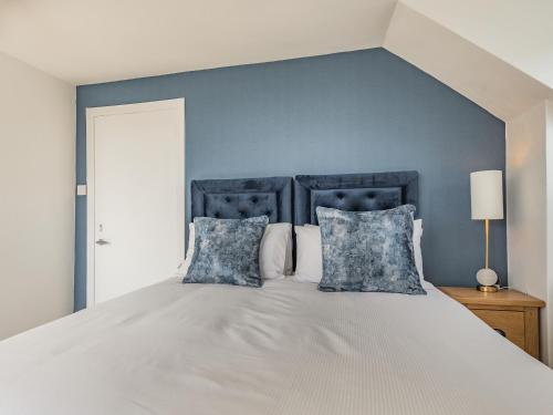 a bedroom with a large bed with blue walls at Brooksyde,Kippford in Kippford