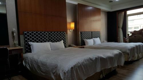 Habitación de hotel con 2 camas y ventana en 雲林斗六御花園汽車旅館, en Douliu