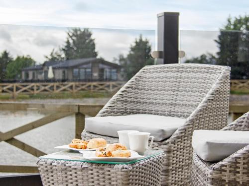 a wicker chair with two plates of donuts and cups at Trincomalee Lodge - Ukc4057 in Nunthorpe