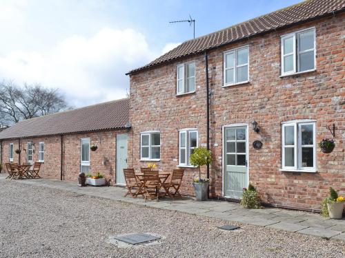 a brick building with chairs and tables in front of it at Copper House - 18435 in Bempton
