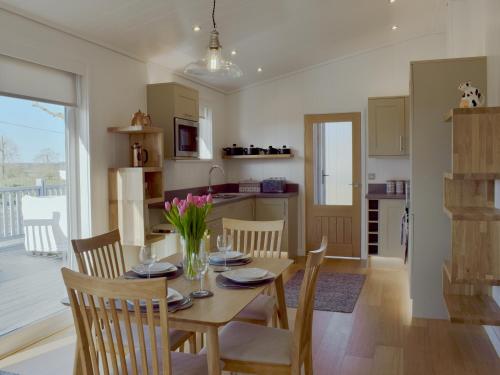 a kitchen and dining room with a table and chairs at Cree Lodge - Uk13636 in Creetown