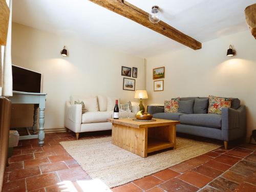 a living room with a couch and a table at New Lane Cottage in Worstead
