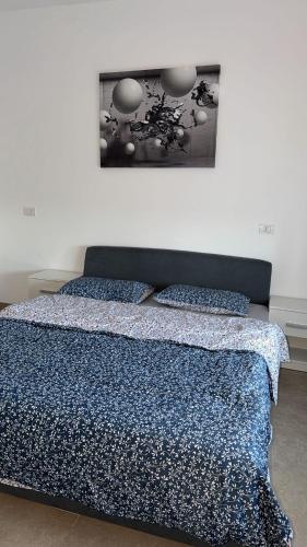 a bed with a blue comforter and two pillows at Casa Focșani in Cîmpineanca