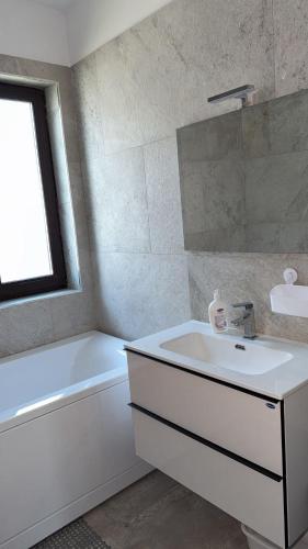 a white bathroom with a sink and a tub and a sink at Casa Focșani in Cîmpineanca