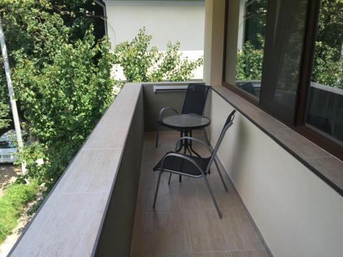 two chairs and a table on the balcony of a house at Paradox Oituz in Eforie Sud