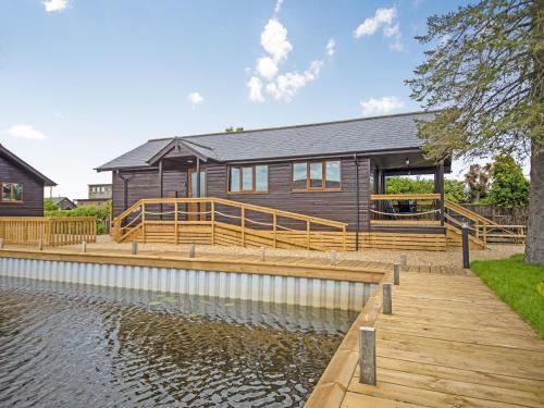 a house with a dock next to a body of water at River Rest-B6863 in Brundall