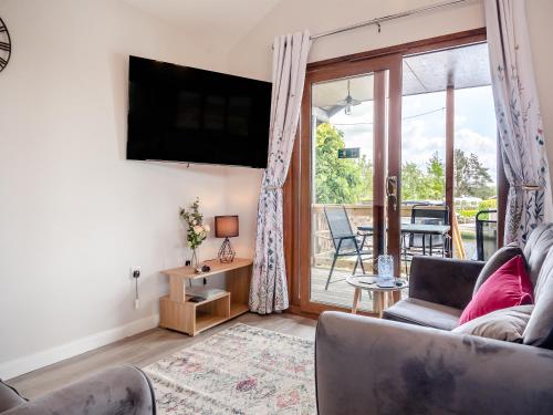 a living room with a couch and a flat screen tv at River Rest-B6863 in Brundall
