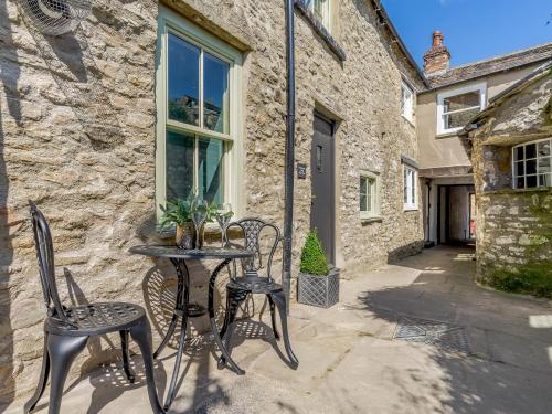 a table and chairs in front of a stone building at Frenchgate Mews in Richmond