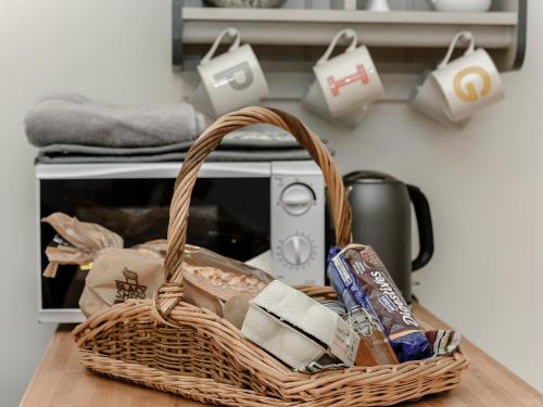 a basket sitting on top of a table with a toaster at Brook Farm Annex in Tenterden