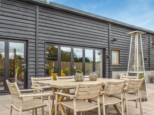 a wooden table and chairs on a patio at Dodds Barn in Fersfield