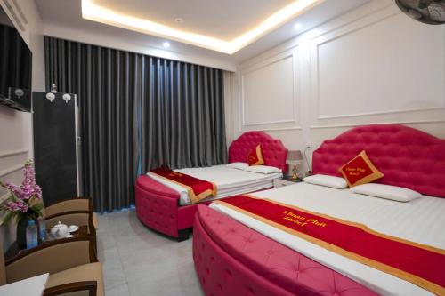 two beds in a room with pink furniture at Nhà Nghỉ Thuận Phát in Làng Chang