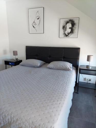 a bedroom with a large bed with two night stands at Appartement meublé Tilff in Esneux