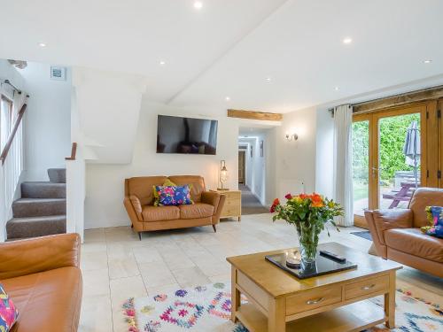 a living room with couches and a table at Willow Barn - Czb in Neatishead